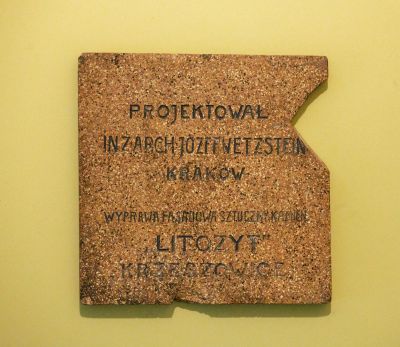 Kolejny "dow&oacute;d" na korzystanie podczas budowy nowej siedziby firmy "I. Schaitter i Sp&oacute;łka" jedynie z lokalnych wyrob&oacute;w przemysłowych  to znajdująca się wewnątrz kamienicy tablica ze sztucznego kamienia. Informuje ona o projektancie kamienicy inż. arch. J&oacute;zefie Wetzsteinie z Krakowa, a także o tym, iż wyprawa fasadowa budynku pochodziła z fabryki sztucznego kamienia "LITOZYT" w Krzeszowicach. Materiał, z kt&oacute;rego została wykonana, daje pojęcie, jak mogła wyglądać oryginalna elewacja budynku. Fot. Bogdan Szczupaj, Pola Antonina Słomińska, Galeria Fotografii Miasta Rzeszowa